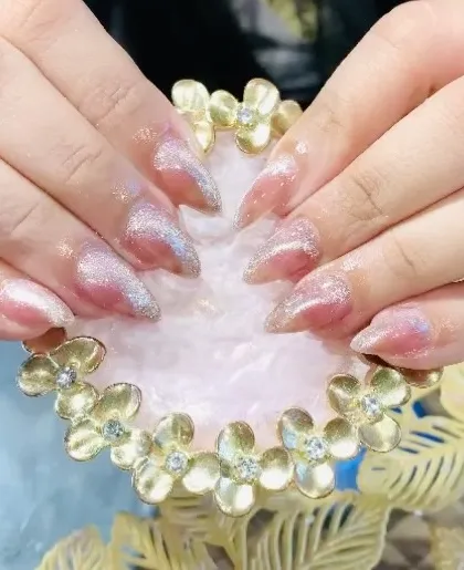 A beautiful set of stiletto nails with a sheer pink base and a silver cat eye effect.