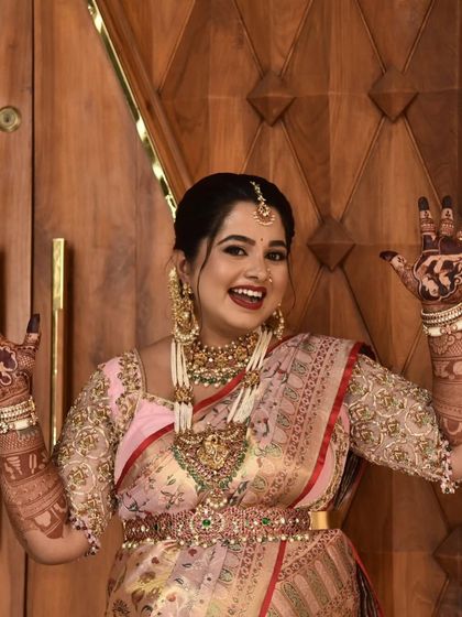 Pure happiness! A joyful mom-to-be shows off her beautiful baby shower mehendi. The design features couple portraits and other personal elements, making her smile even brighter.
