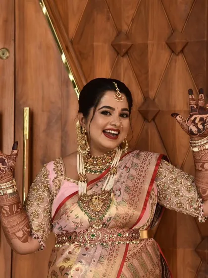 Pure happiness! A joyful mom-to-be shows off her beautiful baby shower mehendi. The design features couple portraits and other personal elements, making her smile even brighter.