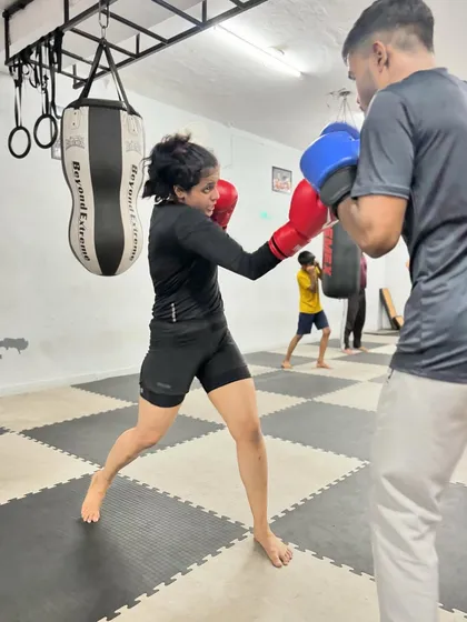 A female boxer practicing her jab in a partner drill. We focus on creating a realistic training environment where students can practice their offense and defense.