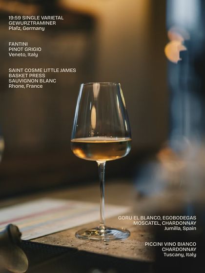 A single glass of white wine from our extensive list. This image highlights some of our selections, including a German Gewürztraminer, an Italian Pinot Grigio, and a French Sauvignon Blanc.