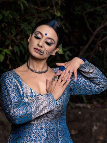 In this shot, the model's pose and closed eyes convey a sense of grace and serenity. My focus was on capturing the intricate silver work of the blue dress and the artistic details of the makeup and jewelry.