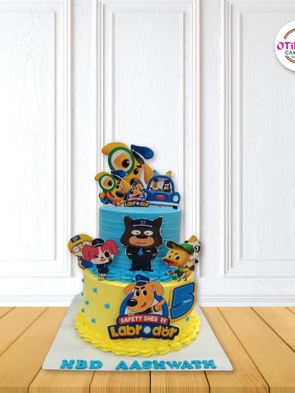 This two-tiered cake is themed around the cartoon 'Safety Sherrif Labrador'. We used bright colors and edible character cutouts to create an action-packed design for a fifth birthday.