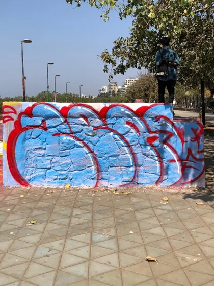 A red and blue throw-up on a public wall at Bandra Skate Park, Mumbai. This is graffiti in its natural habitat, part of the urban fabric.