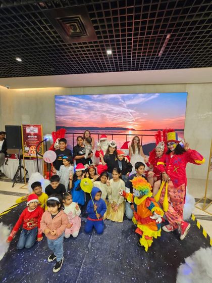 A happy group photo on stage with our performers and young guests. Our clowns, jugglers, and Santa Claus love posing for pictures to help families capture the fun memories from the event.