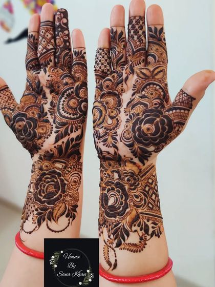 A classic and symmetrical floral design on both hands, perfect for a traditional look. The red bangles add a beautiful pop of color.