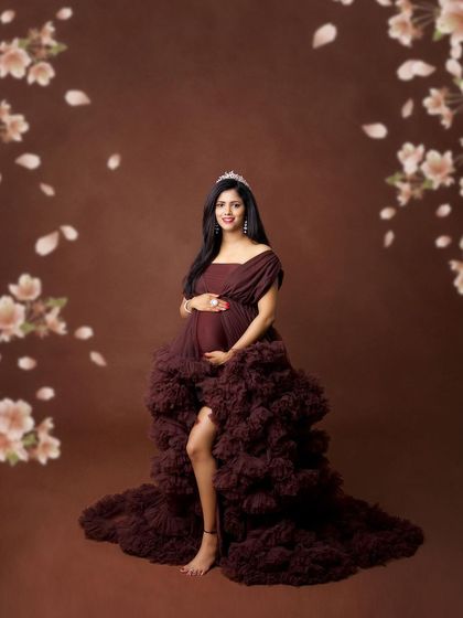 This rich, chocolate-brown ruffled gown is a unique and elegant choice. Paired with a floral background and a tiara, it creates a look of earthy royalty.