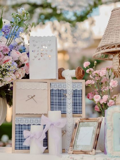 A collection of charming, handcrafted props, including fabric-covered boxes, lace ribbons, and framed pictures.