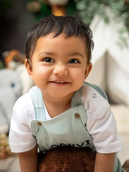A huge smile from the birthday boy. This safari-themed portrait captures the joyful and adventurous spirit of a one-year-old.