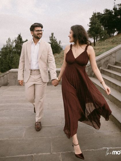 A happy, walking shot of a couple on a stone staircase in Georgia. Their smiles and hand-holding convey a sense of easy, comfortable love against a beautiful, natural backdrop.