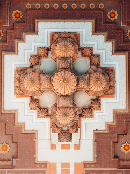 A top-down, abstract view of the architecture of Akshardham Temple in Delhi. This drone shot reveals the incredible symmetry and detail of the temple's domes and patterns.