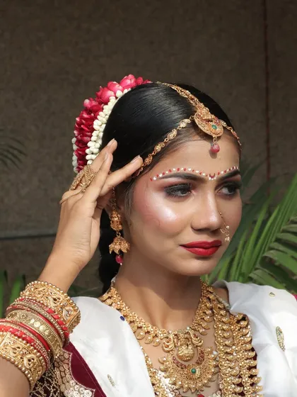 This is a traditional Konkani bridal look from one of our Mumbai seminars. The unique forehead design and the choice of jewelry are specific to this coastal region.