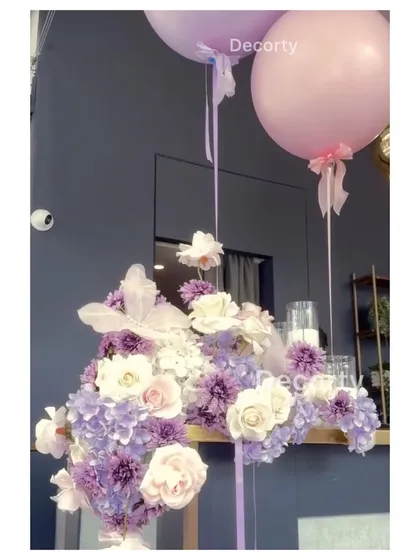 A detailed view of the floral and balloon decor, with large pink and purple balloons creating a lush, textured look.