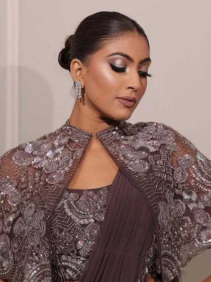 Serving looks and stealing hearts with this glam party style. The focus is on the dramatic, shimmery eye makeup and the elegant updo, creating a look that is pure sophistication.
