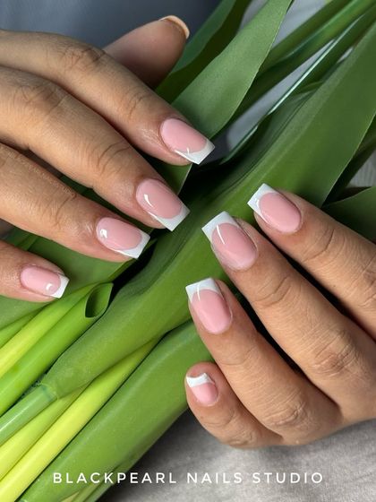 The timeless classic. This image showcases a perfectly executed French manicure with clean, crisp white tips on a natural pink base, shaped into a modern square. It's a testament to precision and elegance.