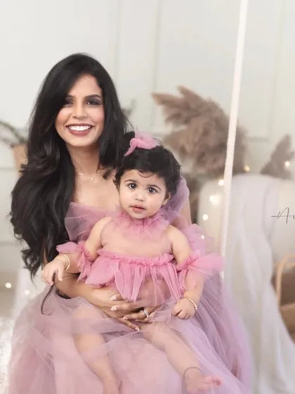 A gorgeous mommy and me portrait from a first birthday session. They are styled in matching shades of pink, creating a sweet and coordinated look.