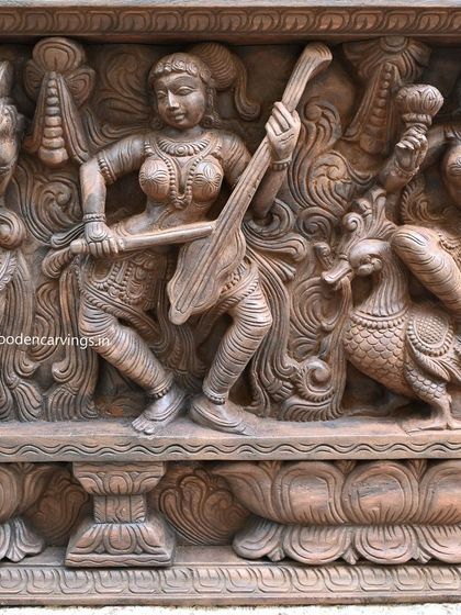 A detailed shot of our 73-inch Apsara panel, focusing on a celestial musician playing the Veena. Notice the intricate carving on her attire and the delicate posture, all brought to life in natural wood.