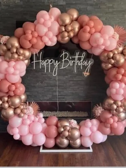 An elegant circular balloon arch in dusty rose and rose gold. This sophisticated color combination is perfect for a chic birthday celebration or bridal shower.