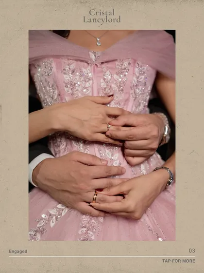 A close-up focusing on the couple's hands and rings, with the intricate details of the bride's pink gown visible. It's all about the texture and details.