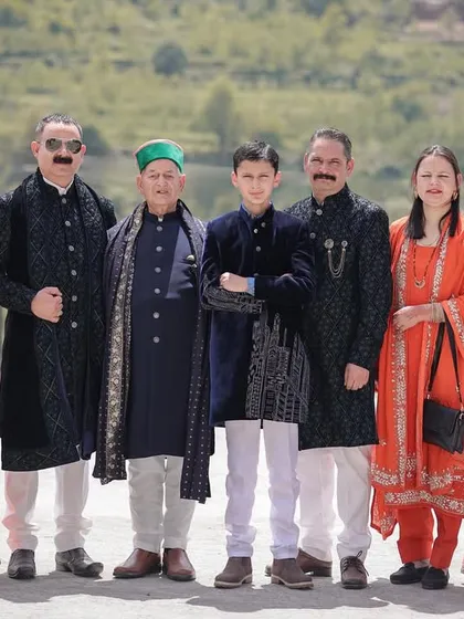 A formal family portrait from a beautiful Himachali wedding, capturing multiple generations dressed in their traditional best.