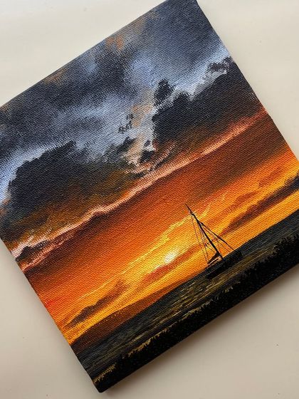 A different angle of the sailboat sunset painting, showing the fine details of the boat and the texture of the water.
