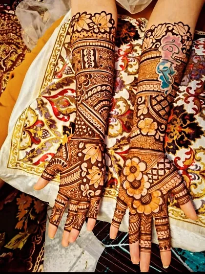A stunning floral-themed bridal design. The arms are covered in a diagonal 'bel' or vine pattern, filled with blooming flowers and leaves, creating a very organic and beautiful look.