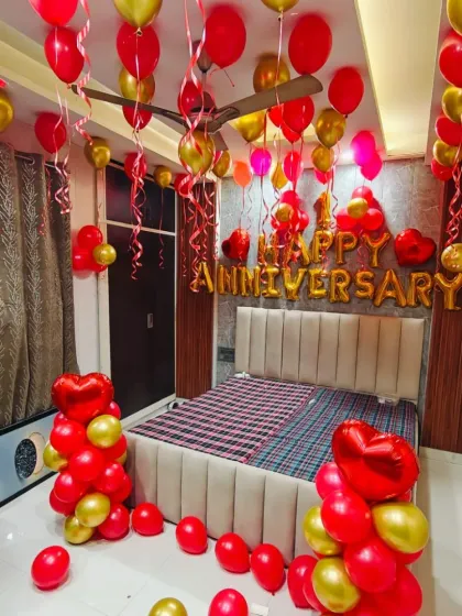 For a classic and romantic surprise, I can transform your bedroom with a full decoration package. This setup includes red and gold latex balloons, "Happy Anniversary" foil lettering, heart-shaped balloon bouquets, and ribbons hanging from the ceiling.