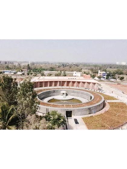 The memorial complex seen from a distance, with the circular gallery and the linear auditorium block creating a dialogue of forms.