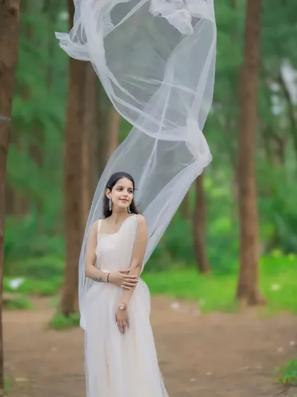 This couple's portrait in the woods has a magical feel, thanks to the flowing fabric of our off-white gown. We provide outfits that help tell your unique love story.