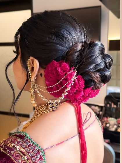 A clear shot of the textured floral bun, highlighting the interplay between the woven hair, the rich color of the flowers, and the delicate jewellery. This updo is designed to be both beautiful and secure.