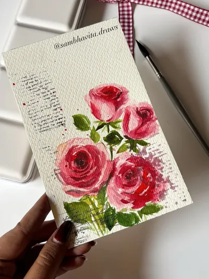 Holding one of my hand-painted rose cards. I use thick watercolor paper that gives the final piece a quality feel, perfect for a special occasion.