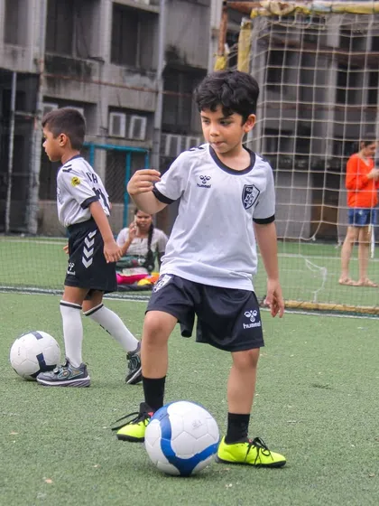 Two players practice ball control side-by-side, learning from each other in a collaborative and supportive training environment.