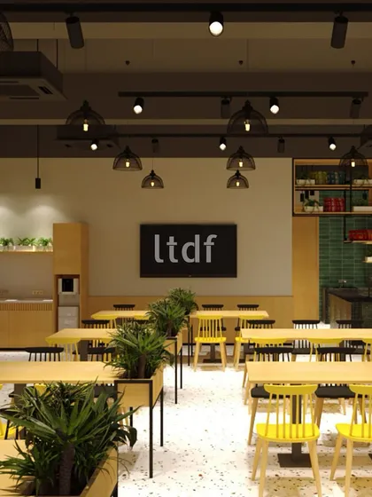 This upcoming institutional cafeteria is designed as a vibrant hub of interaction. Long wooden tables encourage community, potted plants add a touch of greenery, and wire-framed lighting creates an inviting atmosphere that enhances the student experience.