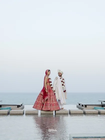 The couple stands by the infinity pool, a serene portrait after their Indian wedding ceremony. The vastness of the sea reflects the journey ahead of them.