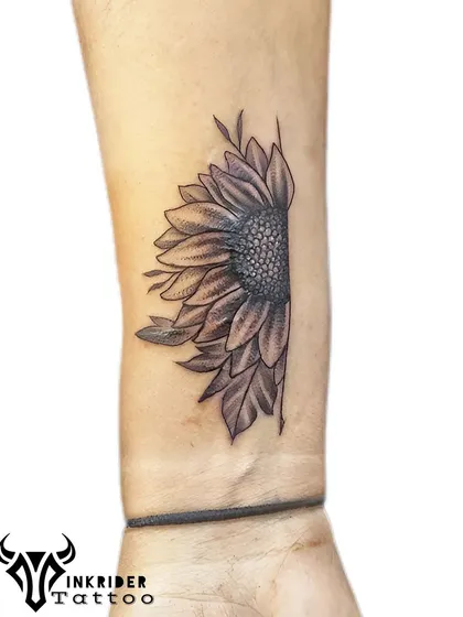A half-sunflower tattoo on the wrist. This design is a unique take on a popular flower, symbolizing adoration and loyalty.