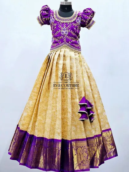 An elegant combination of cream and purple. The Kanchi Pattu skirt is paired with a beautifully embroidered purple blouse.