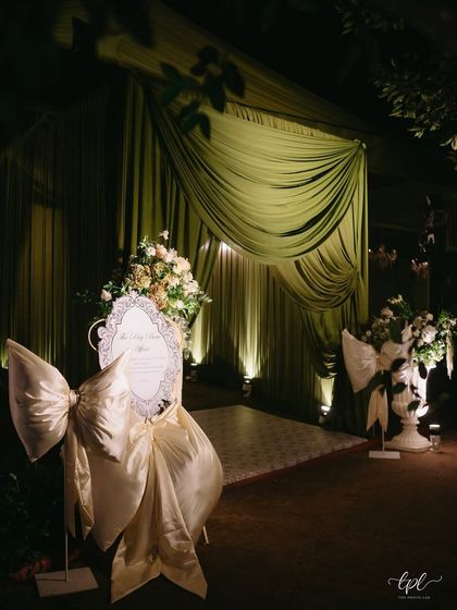 The entrance to the reception was a grand statement, with lush green velvet drapes and oversized satin bows welcoming guests into the enchanting space.