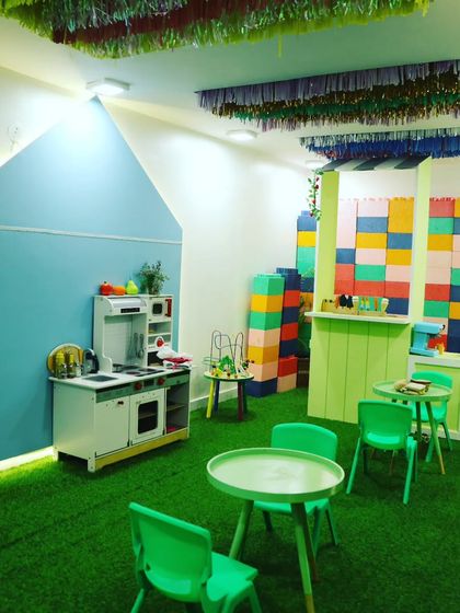 A wide view of our pretend play area, featuring a kitchenette, tables, and giant building blocks for endless creative fun.