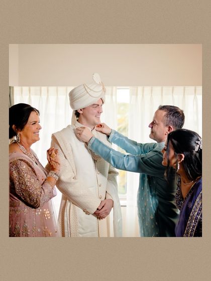 A heartwarming moment as the groom's family helps him with his final wedding attire preparations.