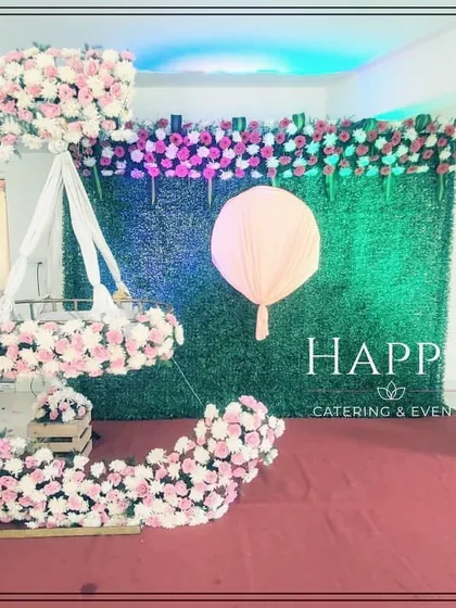 A clean and modern take on the crescent moon theme. This setup uses soft pink and white flowers against a green wall, perfect for a contemporary naming ceremony.