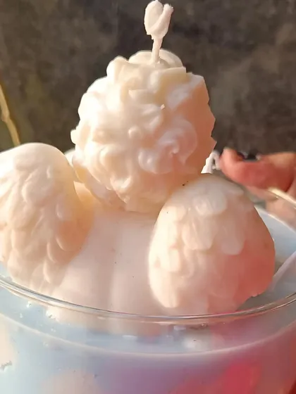A back view of the angel and cloud jar candle, showing the angel's wings.