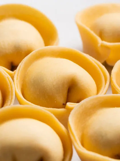 An extreme close-up of fresh tortelloni. This macro view reveals the delicate shape and texture of the handmade pasta.