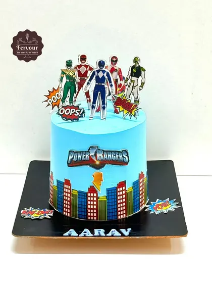 A Power Rangers theme cake for a young fan. This chocolate truffle cake is frosted in bright blue whipped cream and decorated with the iconic superhero team.