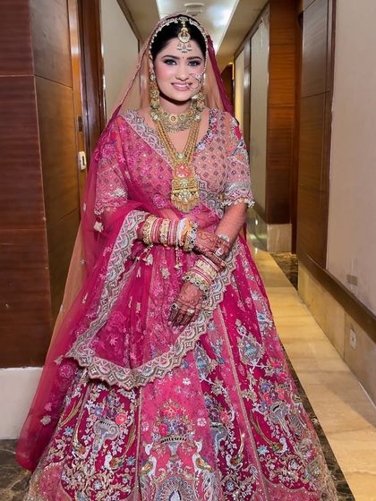 A full-length view of this bride's gorgeous pink lehenga. The makeup features soft pink tones and a radiant finish to match the outfit's delicate and sparkly details.