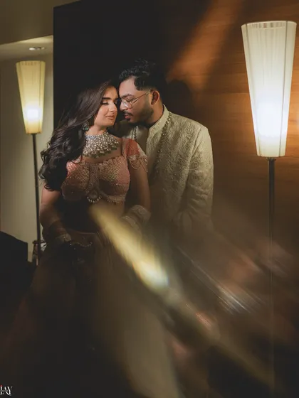 We use creative lighting techniques to add a touch of magic to our photos. This dreamy, artistic shot uses a prism flare to create a soft, romantic glow, perfectly suiting the intimate mood of this indoor couple portrait.
