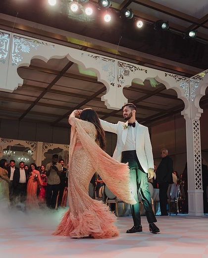 A wide shot of a couple's first dance, showcasing a dramatic turn amidst the fog effect. I help stage these moments to create stunning, photo-worthy memories.