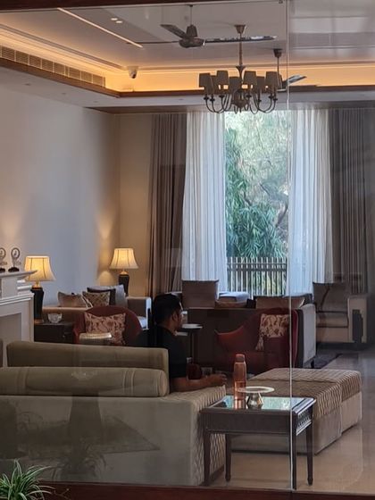 A view through a glass partition into a classically styled living room. This technique creates a sense of openness while subtly defining separate functional areas within the home.