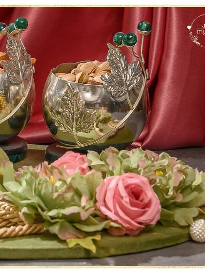Introducing IBITIDAA, my exquisite wedding collection. This hamper features silver bowls with green stone accents, filled with premium nuts and surrounded by delicate flowers.