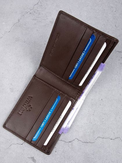 An overhead shot of the open brown wallet, showing its compartments.