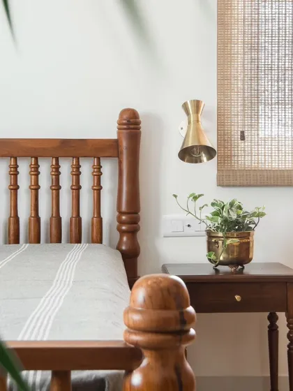 A close-up of the guest bed's headboard and side table, showcasing the detailed woodwork and the simple, elegant styling that defines the room.